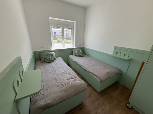 Schlafzimmer mit zwei Einzelbetten in Mintgrün