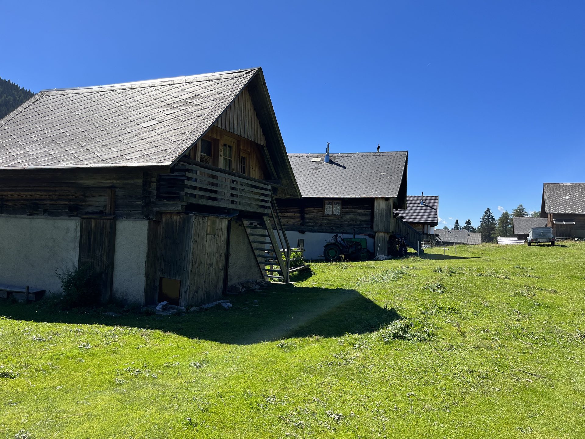 Traditionelle Almhütten in den Karnischen Alpen mit Bergpanorama im Sommer