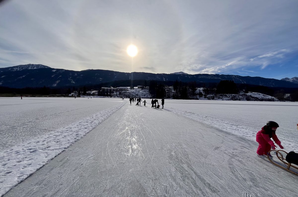 Eislaufen auf der gigantischen Natureisfläche des Weissensees mit Bergpanorama
